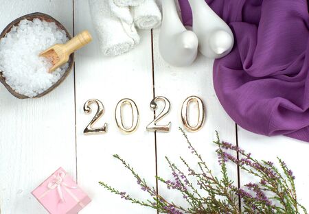 SPA set and gold numbers 2020 on a white wooden board with a purple cloth, figures of birds and a sprig of heatherの写真素材