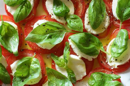 Top view on caprese salad, white mozzarella, red tomatoes and green basil leaves.の写真素材