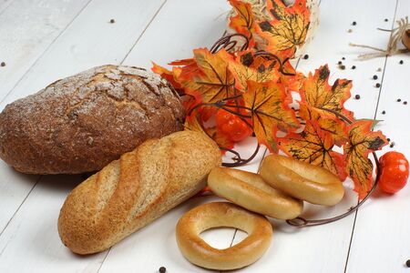 View of bakery on a white wooden table from boards and near orange autumn maple leaves.の写真素材