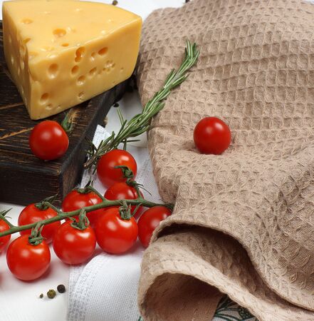 Maasdam cheese, onions and cherry tomatoes on a white table before cooking.の写真素材