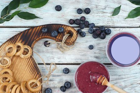 Blueberries and bagels tied with twine on the table, Next to whipped honey in a jar and copy space for your text and advertising, top view.の写真素材