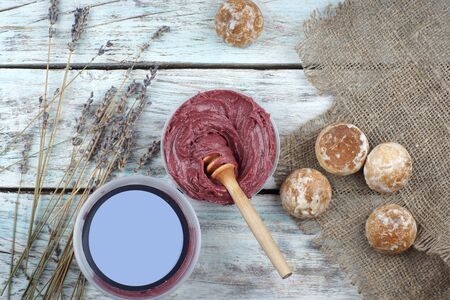 Whipped burgundy color honey and a jar with place for text or advertising, next to a bouquet of lavender and gingerbread cookies, top view.の写真素材