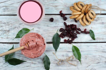 Whipped honey and a jar with a place for text or advertising, next to bagels and dried berries, top view.の写真素材