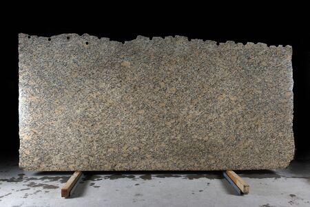 A large slab of natural yellow stone with dark dots called granite Phoenix Yellow.の写真素材