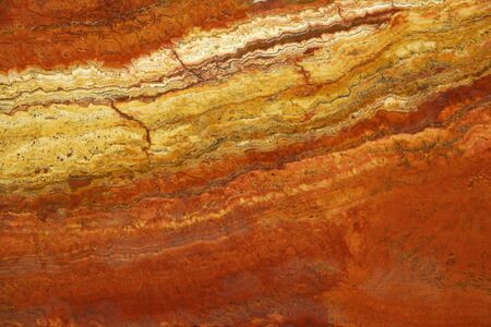 Bright background of natural stone in the colors of lush lava called Travertin Rosso.の写真素材