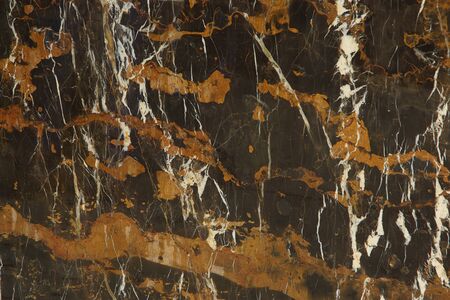 The slab of natural stone in brown with a pattern of yellow and white stripes is called Black and Gold.の写真素材