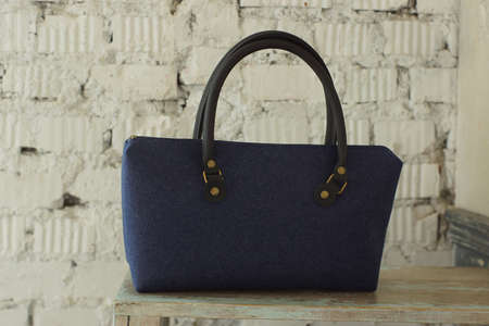 Felt bag on white brick wall background.の写真素材