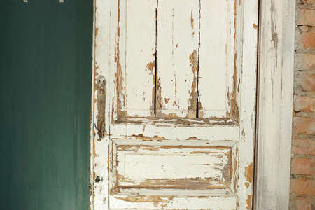 Old, white painted doors, closed, indoors with red brick wall and green wall.の写真素材