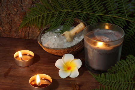 Spa set on a wooden table with burning candles.の写真素材