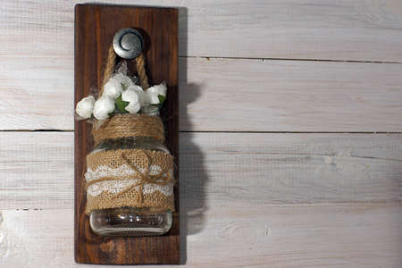 Jar with decor hanging on a white wall