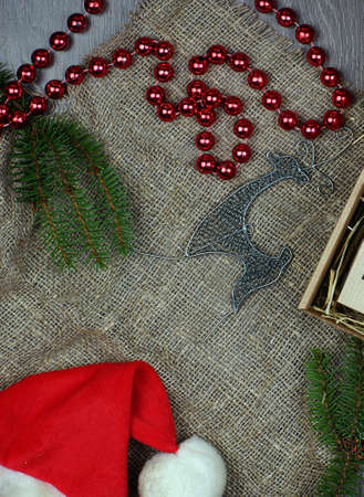 Attributes of christmasnew year in layout on gray background. Spruce branches next to beads and a deer.の写真素材
