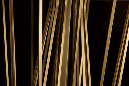 Golden sticks made of metal on a black backgroundの写真素材