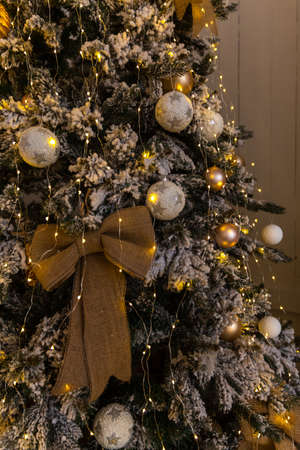 An incomparable Christmas tree decorated with the whole family stands in the hallway with a huge bow and toysの写真素材