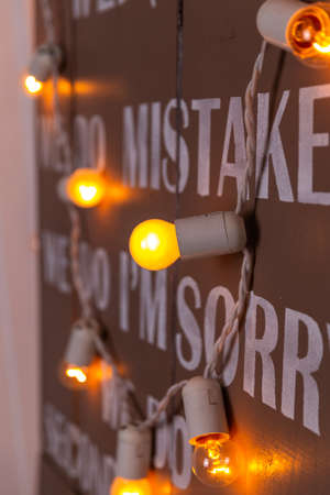 Delicate light of a garland with large bulbs on a painted wallの写真素材