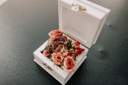 Wedding rings of newlyweds in a beautiful box with flowersの写真素材