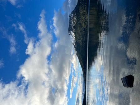 Reflection of blue sky with white clouds in the water surface.の写真素材