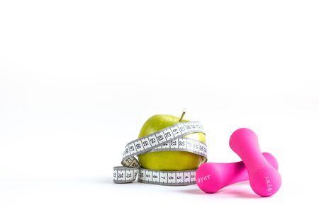 Apple with measuring tape and dumbbells on isolated backgroundの写真素材