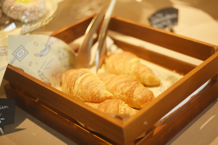 Croissants on a basket weave in a bakery shop. Fresh butter croissantsの写真素材