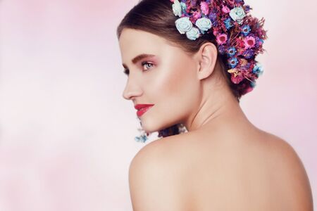 Beautiful young woman with delicate flowers in their hair. Beauty Girl with Flowers Hairstyle. Model...