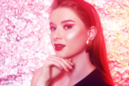 Gorgeous blonde on a bright bokeh background. Girl with pink makeup, in the style of 20x 60s. Girl on a pink background, art photo. Disco girl at the party.の写真素材