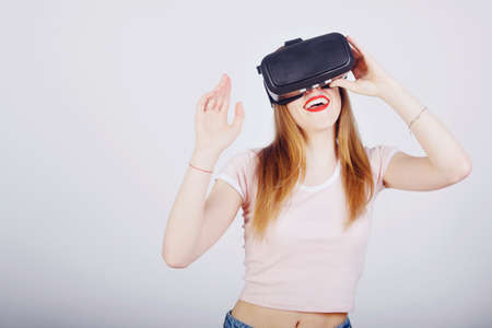 Girl on a white background plays virtual reality. Games and films vr. Emotions
