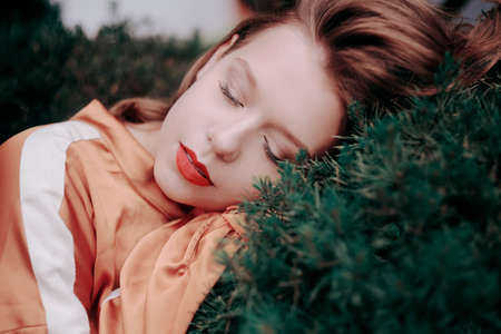 Chic beautiful model on a background of wood, nature, greenery, spruce. Girl with short hair and a...