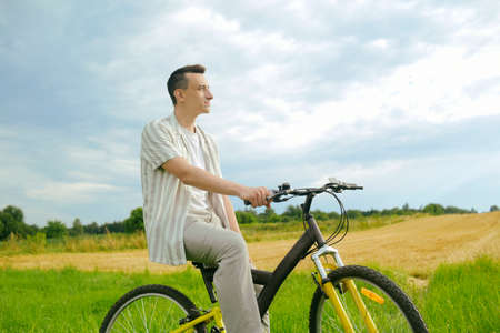 A man on a mountain bike. A fashionable guy came to nature in the field.の写真素材
