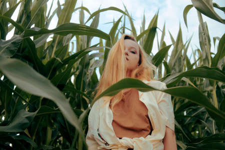 Fashion photo of a girl in a cornfield. Blonde in nature. Agriculture, health, travelの写真素材