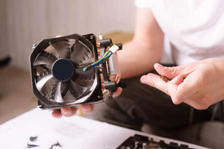 Computer technician installs cooling system of computer. Engineer repairing computer (pc) board....