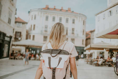 The girl traveler walks around the city with a backpack. Split Croatiaの写真素材