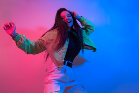 The brunette dances in neon, the dancer in red-blue. Hip hop girl, party, smile.の写真素材
