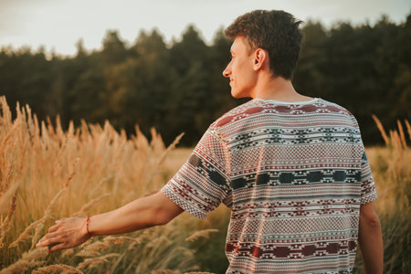 A gorgeous photo of a man walking in the forest against the background of a wheat field. A man on the background of a sunset, a guy guoya in the forest, natureの写真素材