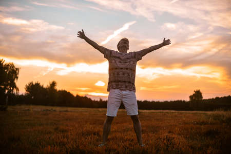 A man in the forest runs on the field, a happy man rejoices in freedom and tranquility. The guy in the field.の写真素材