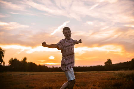 Man in the field at sunset enjoy life smiling, happy with victory, good news, screams, freedom.の写真素材