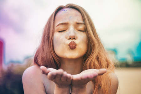 Holi Festival Of Colors. Portrait of happy young pretty girl on holi color festival. Girl kiss with colorful long pink and blue hair. Colorful powder paint on dress. Energy, dancing, beautiful womanの写真素材