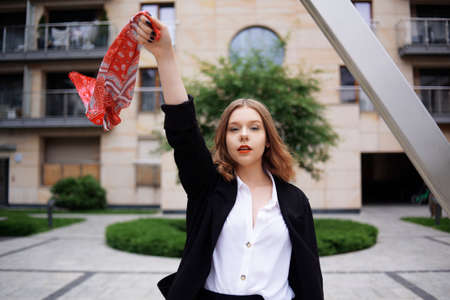 Student, manager, realtor, girl in a white shirt on the background of the building posing. Beautiful blonde with short hair. Model with red lips and a black jacket.の写真素材