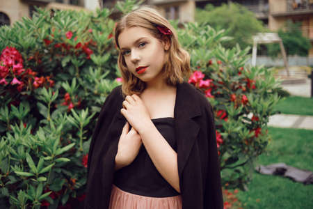 Portrait of a gorgeous girl with hair in flowers, a blonde against a background of pink flowers, a summer photo in a fashionable tint. Beautiful model with a short haircut in a fairy gardenの写真素材