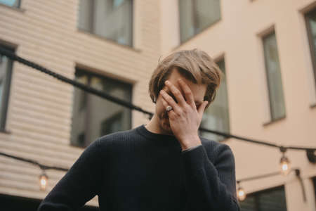 Man in wireless headphones outdoor, street, restaurant. Man listening to e-book, the guy is listening to music.の写真素材