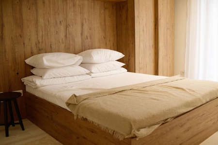 Bedroom, large bed. Wooden interior. The bed is made of wood.の写真素材