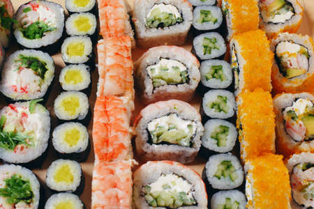 Maki and nigiri, sushi with fish, fresh salmon, shrimp and cheese, avocado rolls. Futomaki and Philadelphia with California. Set of sushiの写真素材