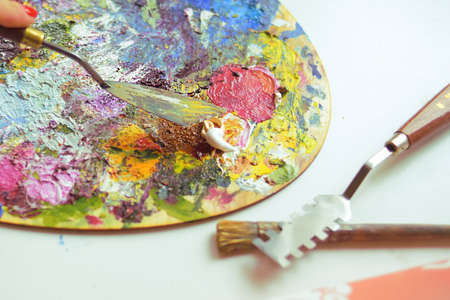 Brushes and palette for painting with paints, Wooden board, brushes and paints. Artist's workplace...