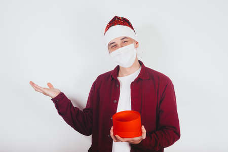 New year christmas covid mask and celebration. The guy in the mask shows to the side the place for...