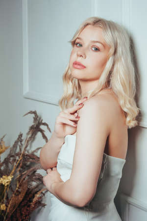 Gorgeous portrait of a blonde woman in a wedding dress. Bride at a wedding, beauty photo for a dress salon. Girl with soft pink makeup.の写真素材