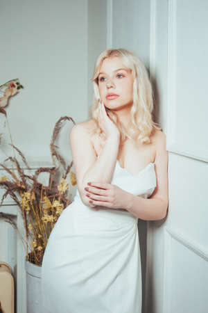 Gorgeous portrait of a blonde woman in a wedding dress. Bride at a wedding, beauty photo for a dress salon. Girl with soft pink makeup.の写真素材
