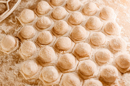 Making homemade dumpling dough. The rolling pin rolls out dough, flour and a mold for dumplings or ravioli. Home cooking food. National cuisine.の写真素材