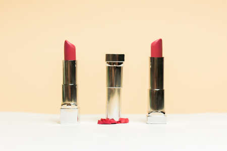 Lipstick different colors, shades options. Cosmetics on nude background. Beautiful examples of lipsticks, pink and red. One lipstick crushedの写真素材