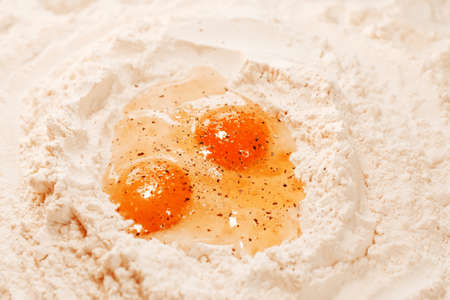 Cooking homemade dough, flour and eggs on the table. Pepper on eggs. Cooking at home, recipes, dietの写真素材