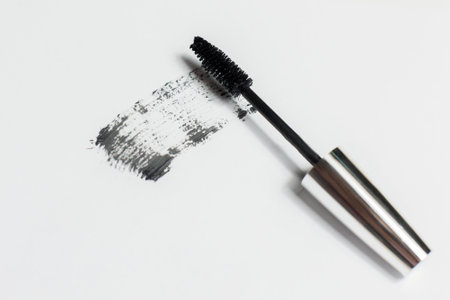 Mascara lies on a white background, and leaves a black mark showing how the brush works. Cosmetics and make-up personal care.の写真素材