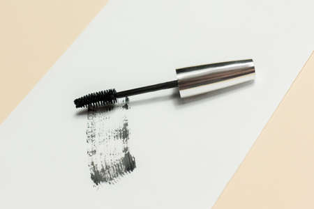 Mascara lies on a white background, and leaves a black mark showing how the brush works. Cosmetics and make-up personal care.の写真素材