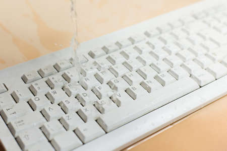 Keyboard in the water, waterproof keyboard, spilled water on the computer. I flooded the keyboard with liquid, what to do.の写真素材